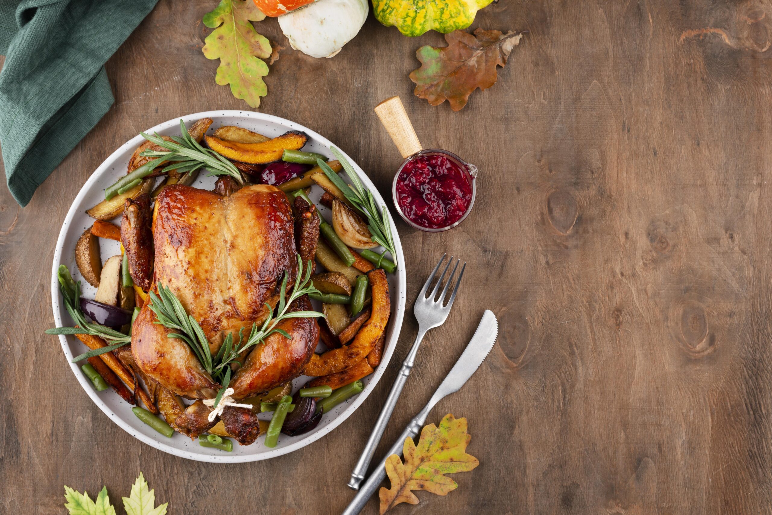 Weihnachtsbraten mit Rosmarin, Kartoffeln und Preiselbeeren auf Tisch angerichtet