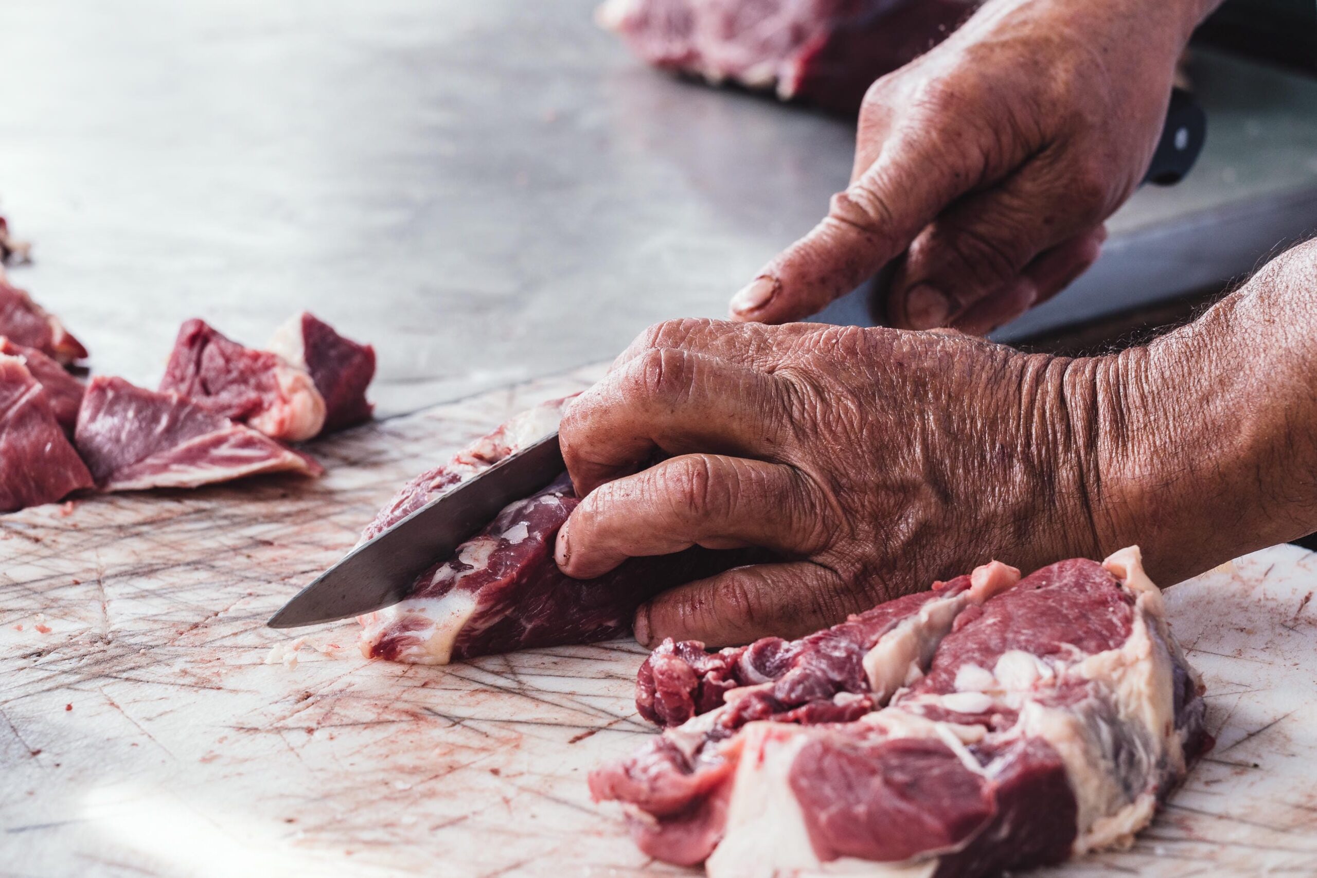 Rohes Fleisch wird mit einem Messer geschnitten